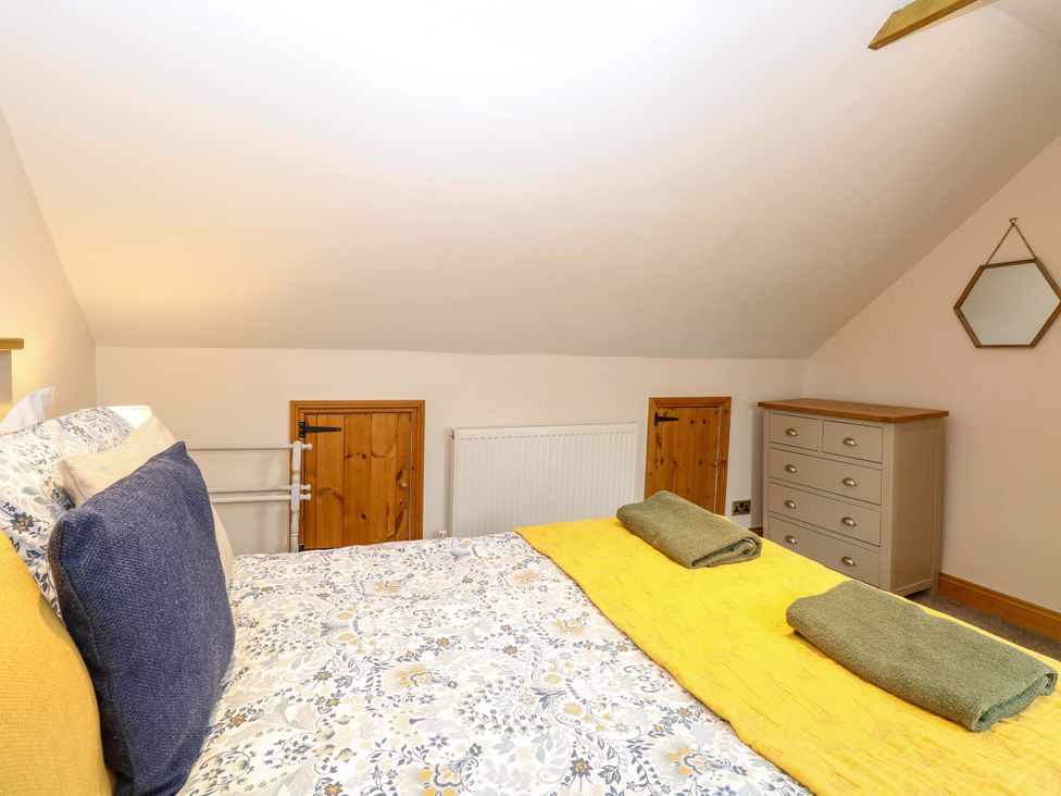 A bedroom with a bed and wardrobe at Fern Cottage Heacham