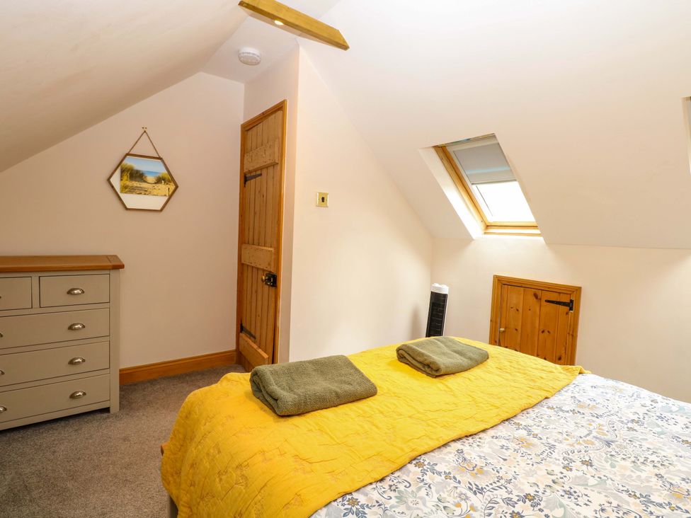 A bedroom with a bed and dresser at Fern Cottage in Heacham