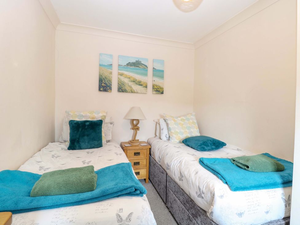 A bedroom with two single beds and wall art at Fern Cottage in Heacham