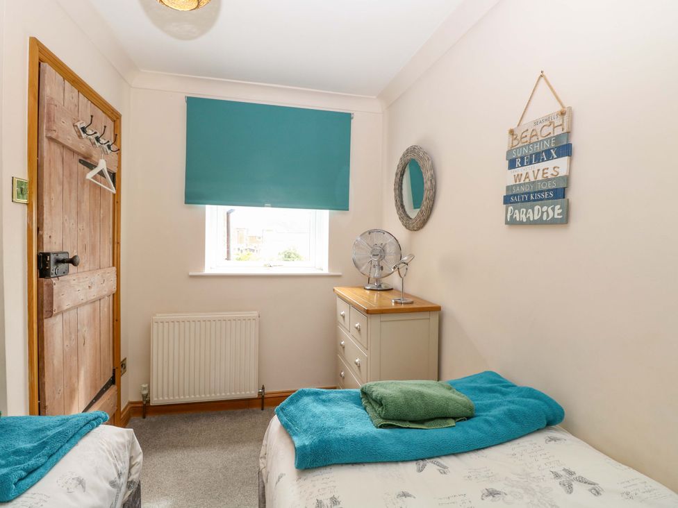 A bedroom with twin beds and a dresser at Fern Cottage in Heacham