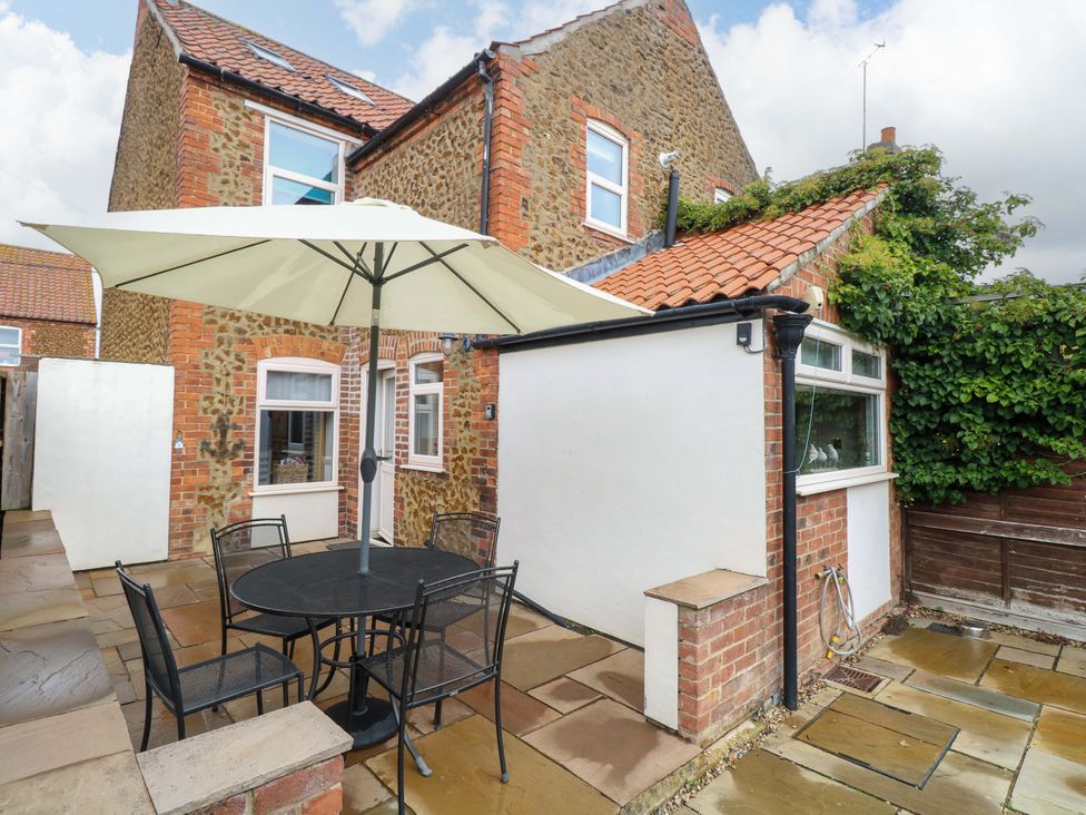 An outdoor area with a table and chairs at Fern Cottage Heacham