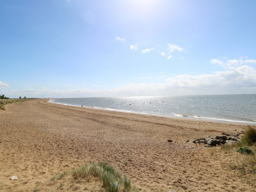 A beach with sand and sea at Fern Cottage in Heacham