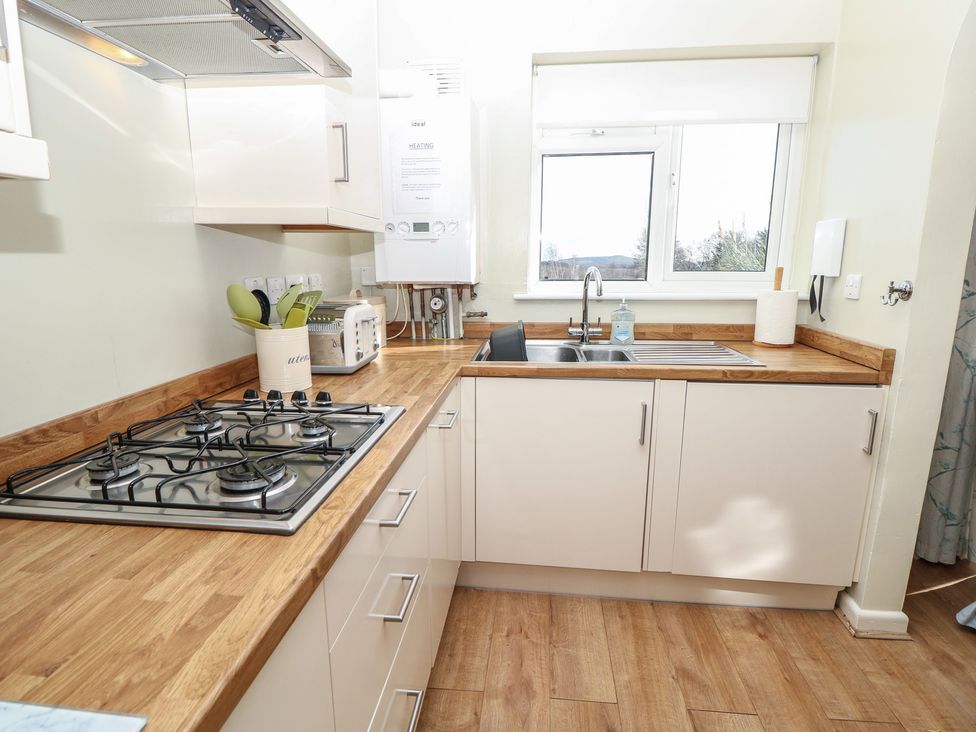 A kitchen with a stove and sink at Roebeck Retreat in Ryde