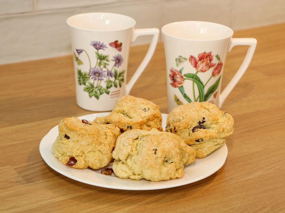 A plate with scones and two teacups on a kitchen counter at Brookside Barn in Bradwell