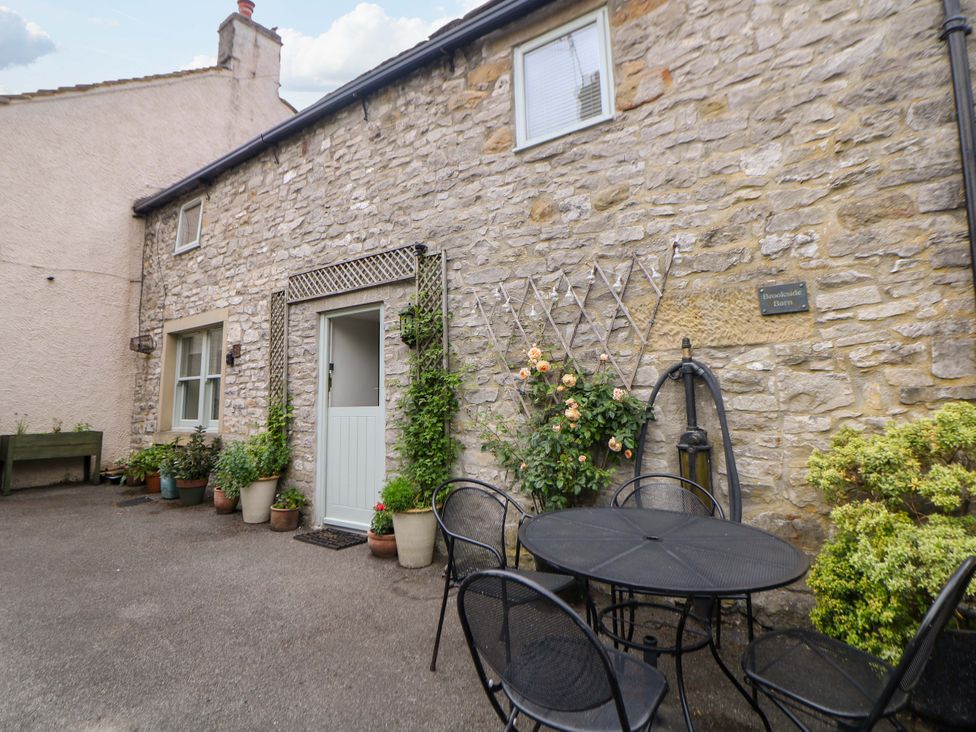 An outdoor seating area with a table and chairs at Brookside Barn in Bradwell