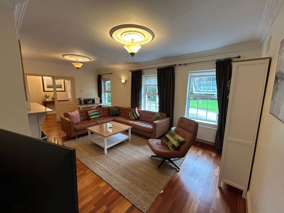 A living room with a sofa, coffee table, and armchair at The Sanctuary in Killavullen near Mallow