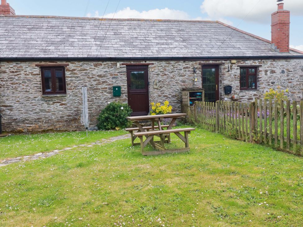 A cottage with a picnic table and garden at 4 Mowhay Cottages in Gorran Haven