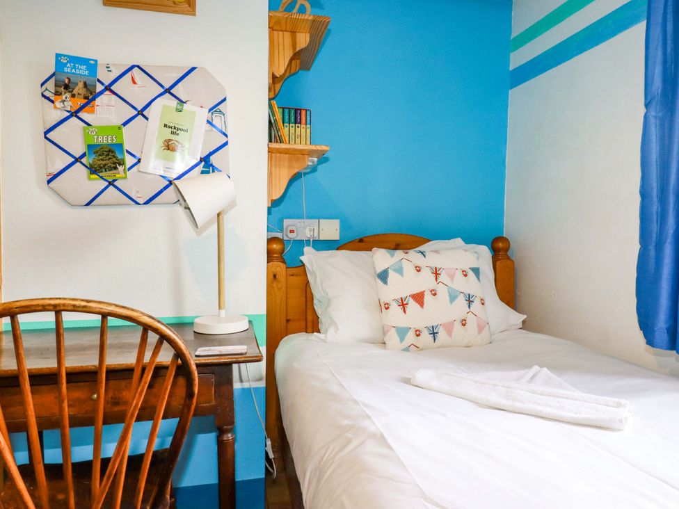 A bedroom with a bed and desk at 4 Mowhay Cottages in Gorran Haven