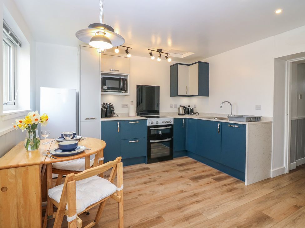 A kitchen with appliances and a dining table at Alt na Voir in Tomintoul