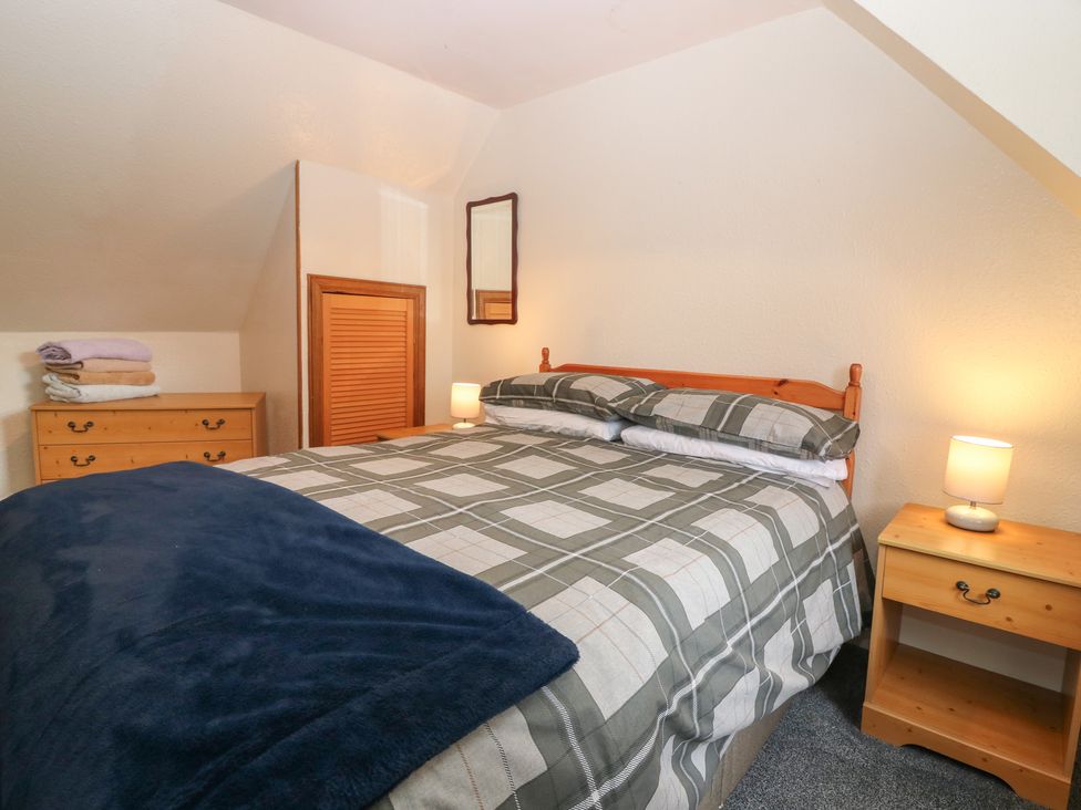 A bedroom with a bed and nightstands at Alt na Voir in Tomintoul