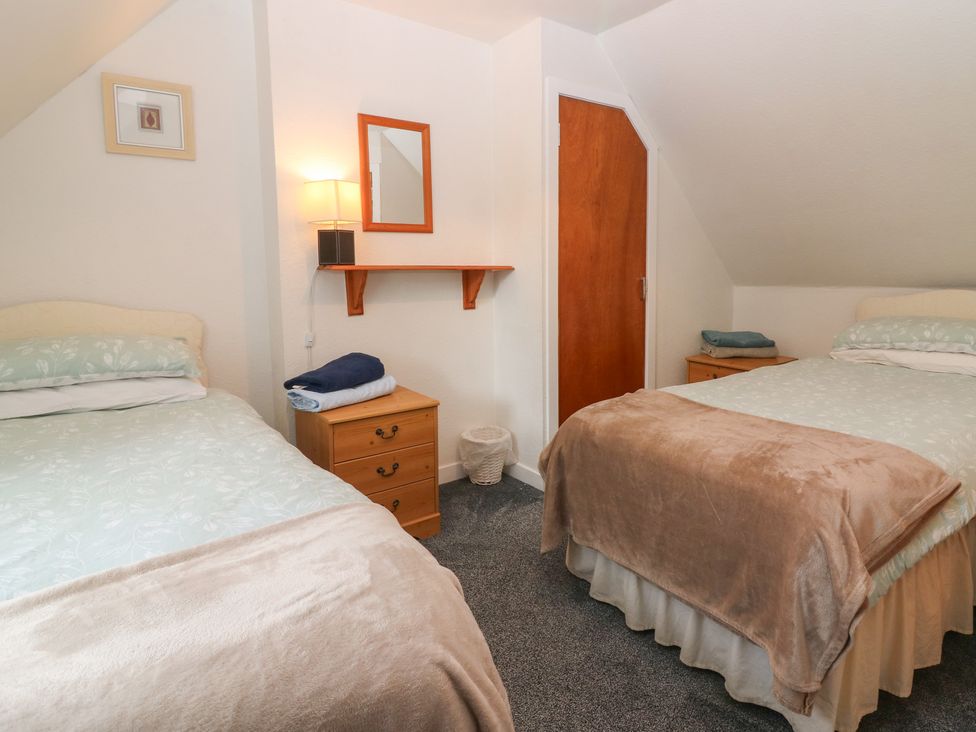 A bedroom with two beds and a shelf at Alt na Voir in Tomintoul