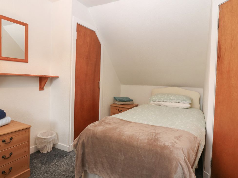 A bedroom with a bed and a mirror at Alt na Voir in Tomintoul