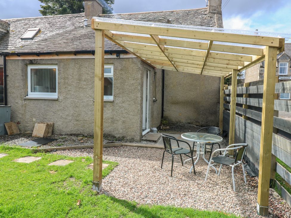 A garden area with a table and chairs under a canopy at Alt na Voir in Tomintoul
