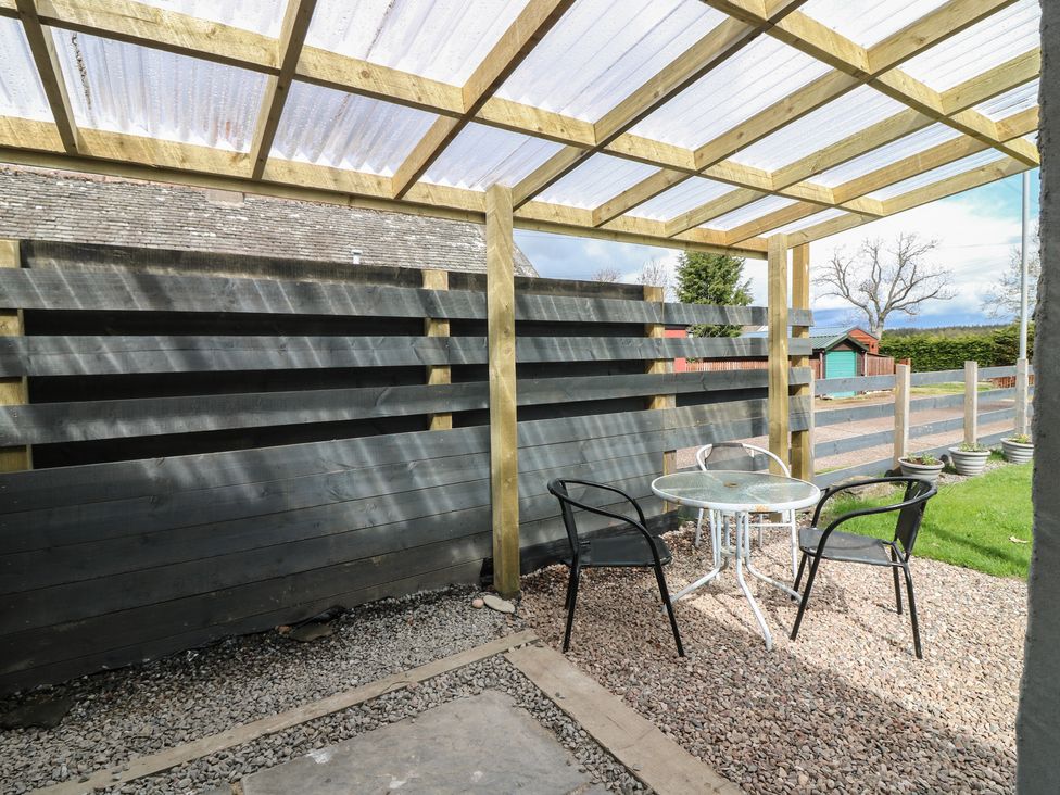 A patio area with a table and chairs at Alt na Voir in Tomintoul