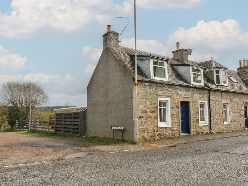 A house with a blue door on a corner in Tomintoul