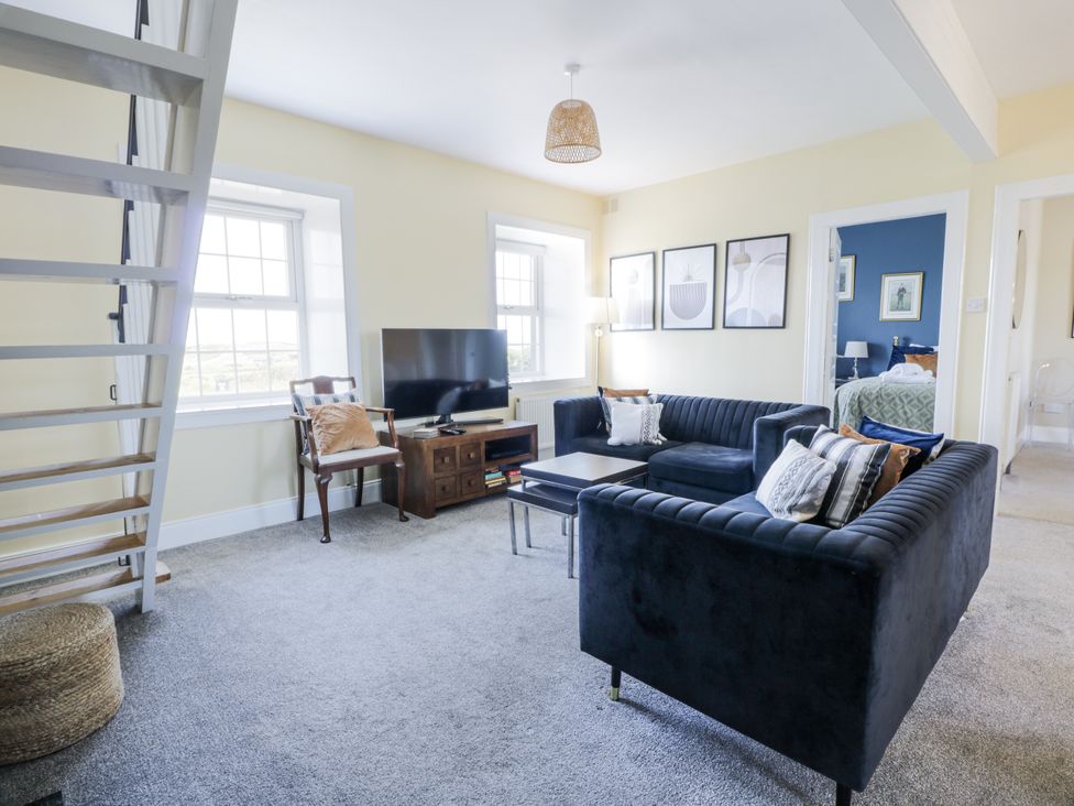 A living room with a sofa and television at Ailsa Shores in Turnberry