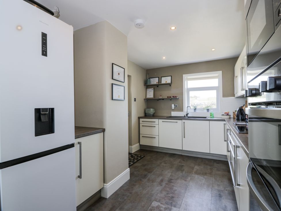A kitchen with refrigerator and cabinets at Ailsa Shores in Turnberry