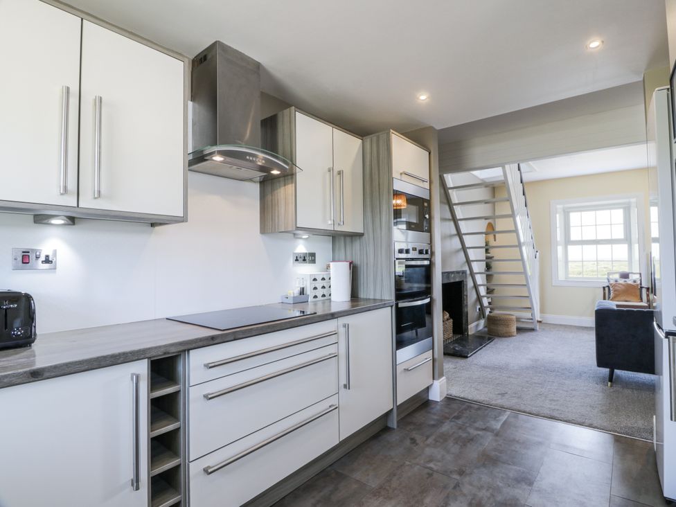 A kitchen with cabinets, stove, and oven at Ailsa Shores, Turnberry