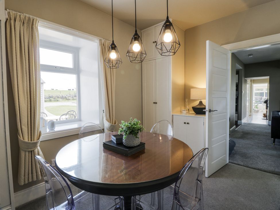 A dining room with a round table and chairs at Ailsa Shores in Turnberry