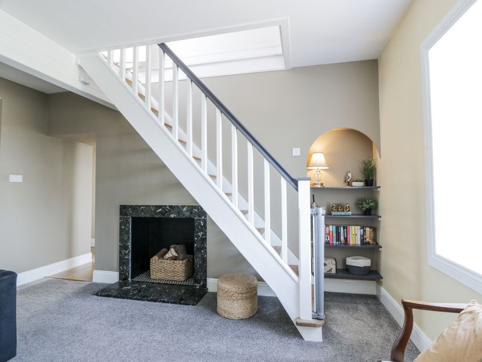 A living room with a staircase and fireplace at Ailsa Shores in Turnberry
