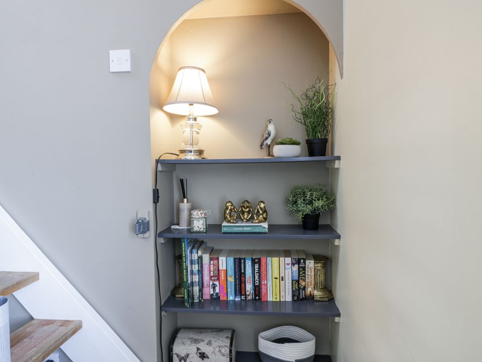 A shelf with books and decor items at Ailsa Shores in Turnberry