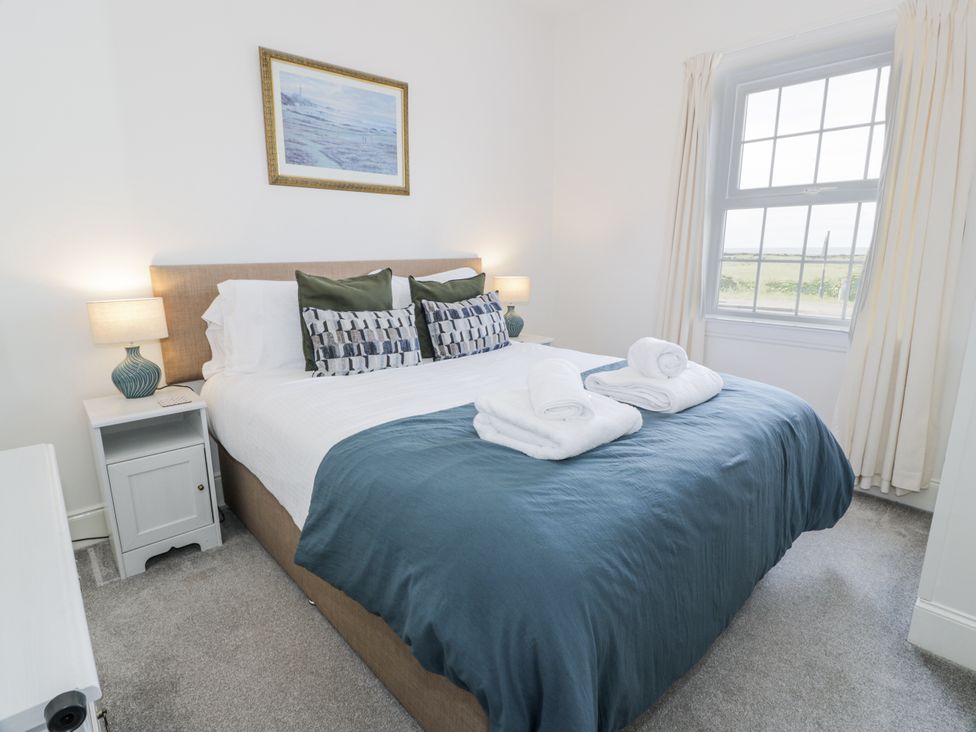 A bedroom with a bed and bedside table at Ailsa Shores in Turnberry