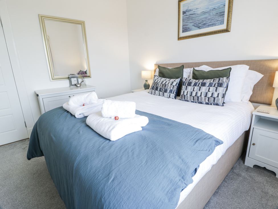 A bedroom with a bed and towels arranged at Ailsa Shores in Turnberry