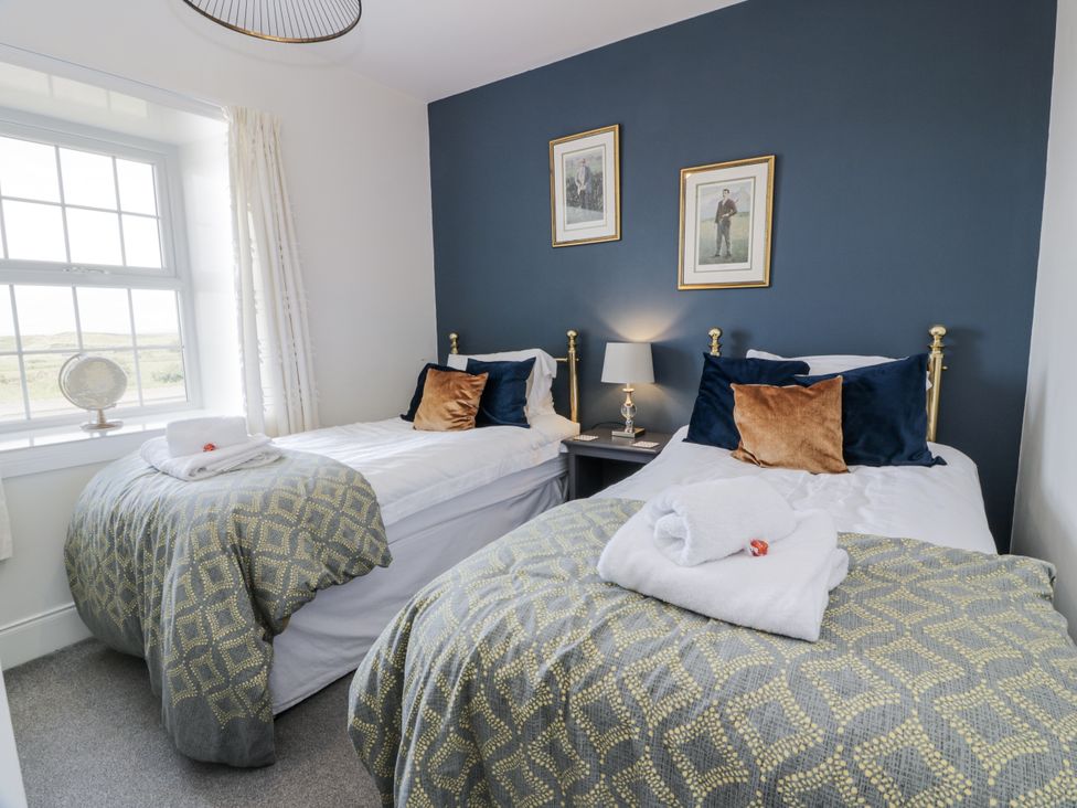 A bedroom with two beds and a nightstand at Ailsa Shores Turnberry