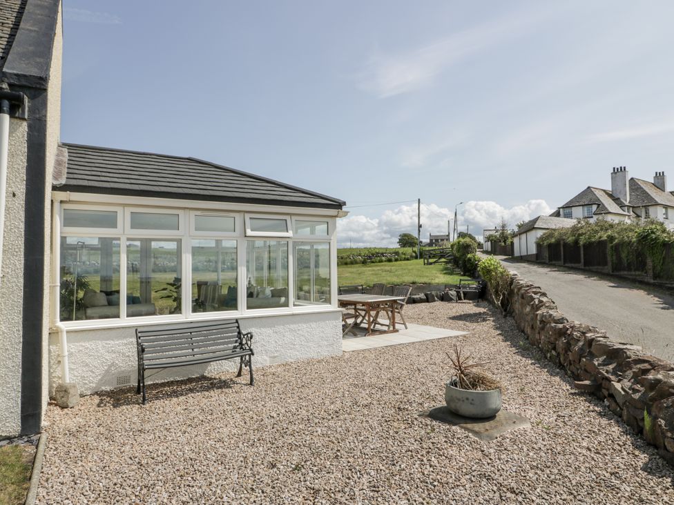 A conservatory with a bench and table at Ailsa Shores in Turnberry