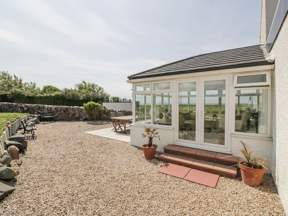 A conservatory and garden area with gravel and seating at Ailsa Shores in Turnberry