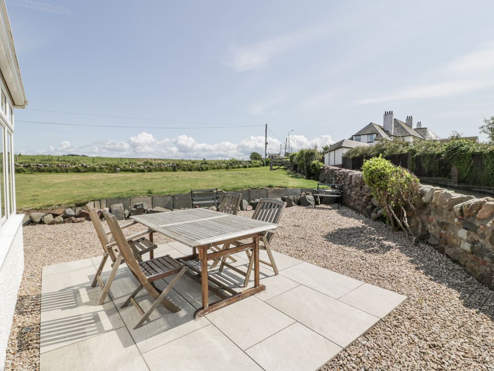 A garden with a table and chairs at Ailsa Shores in Turnberry