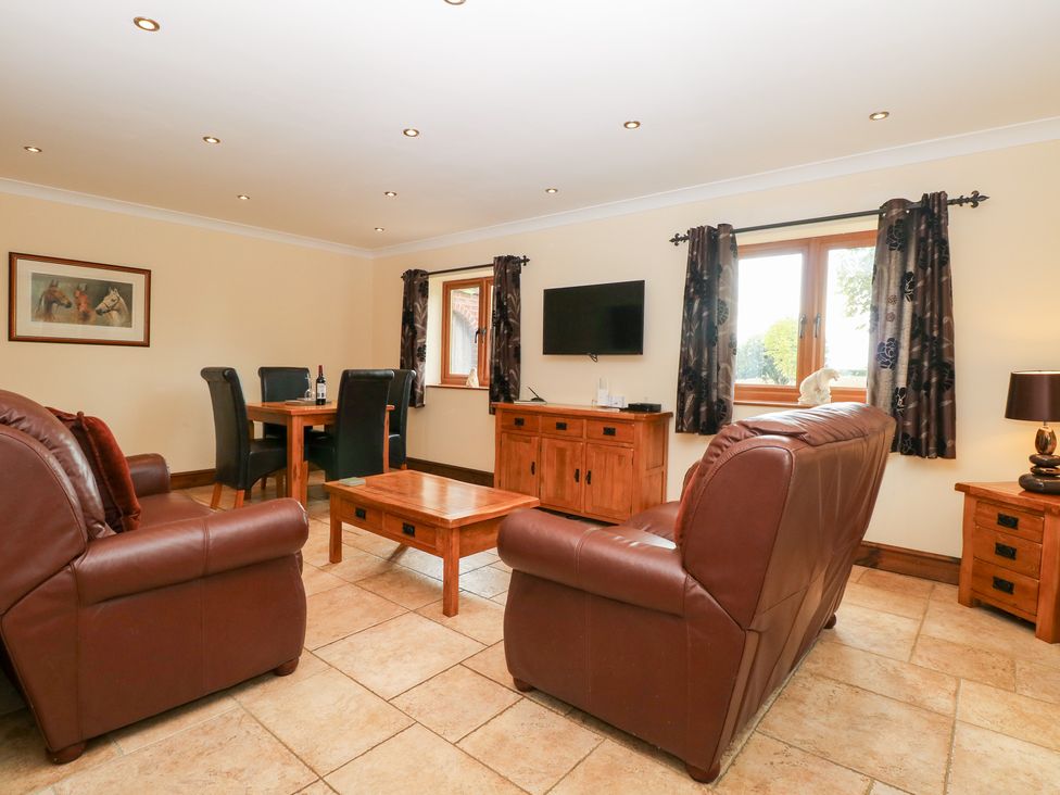 A living room with a sofa and dining table at The Annexe in Litcham