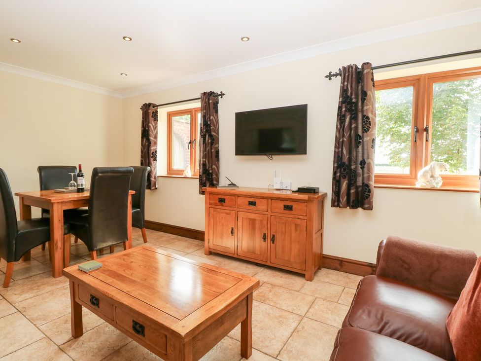 A living room with a dining area and television at The Annexe in Litcham
