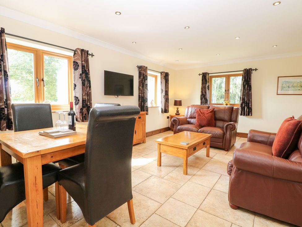 A living room with a dining table and sofa at The Annexe in Litcham