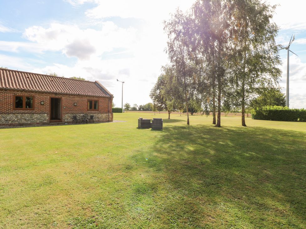An outdoor area with a house and furniture at The Annexe in Litcham
