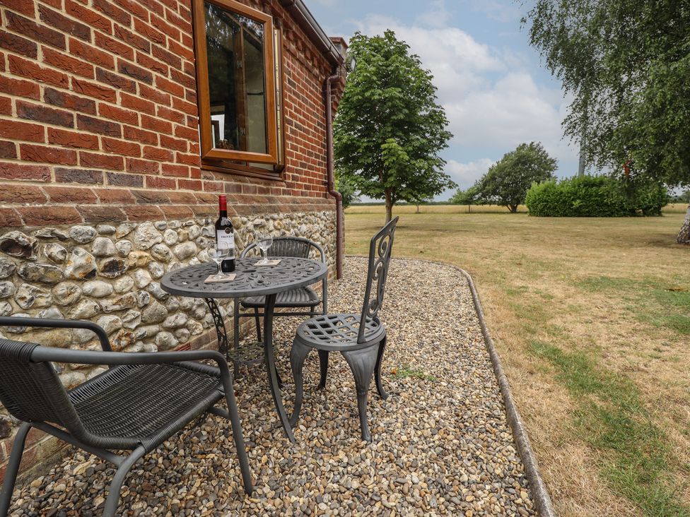 A table and chairs with a wine bottle at The Annexe in Litcham