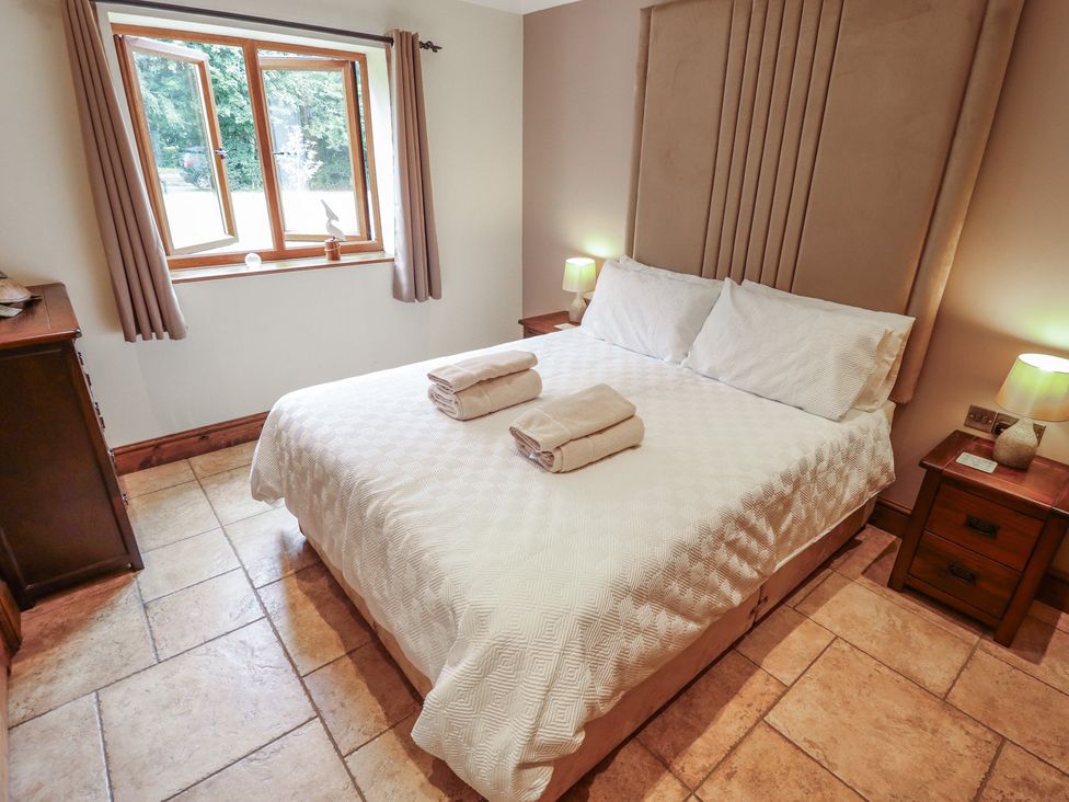 A bedroom with a bed, window, and bedside tables at The Annexe Litcham