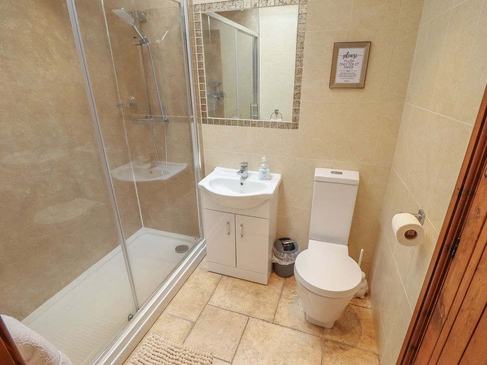 A bathroom with a shower, toilet, and sink at The Annexe Litcham