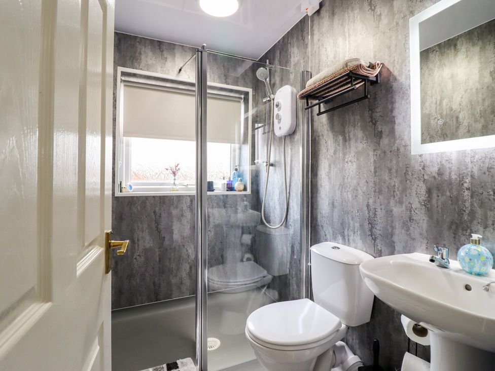 A bathroom with a shower, toilet, and sink at Chy Bean Abergele