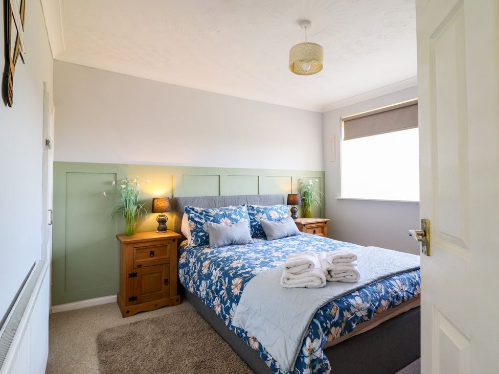 A bedroom with a bed and bedside table at Chy Bean in Abergele