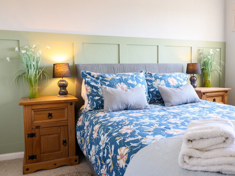 A bedroom with a bed and bedside tables at Chy Bean in Abergele