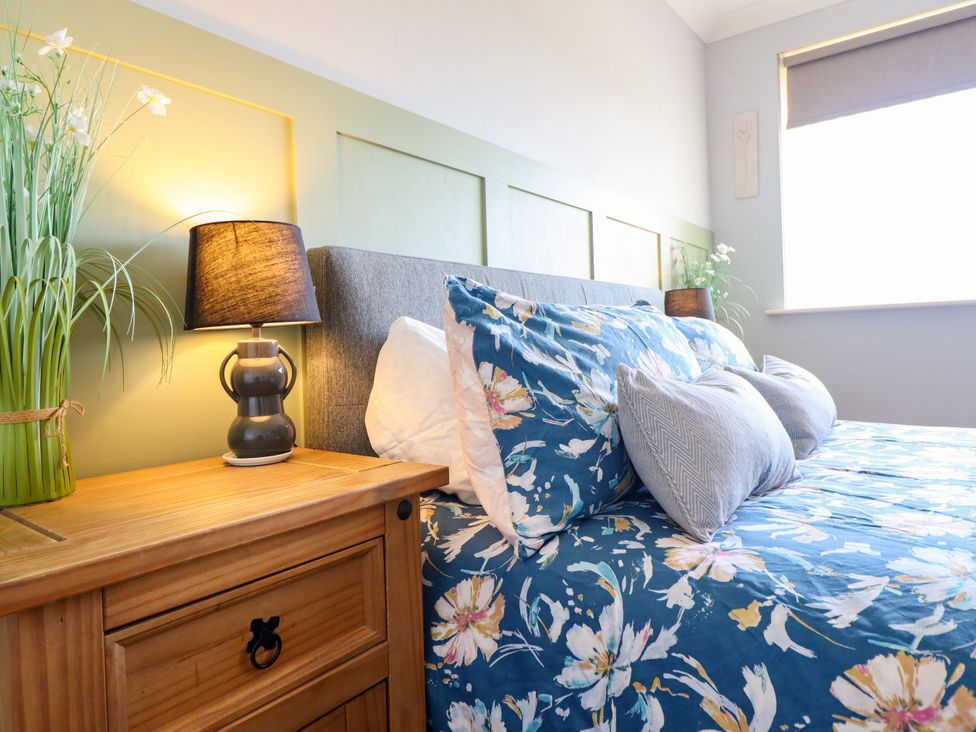 A bedroom with a bed and bedside table at Chy Bean Abergele