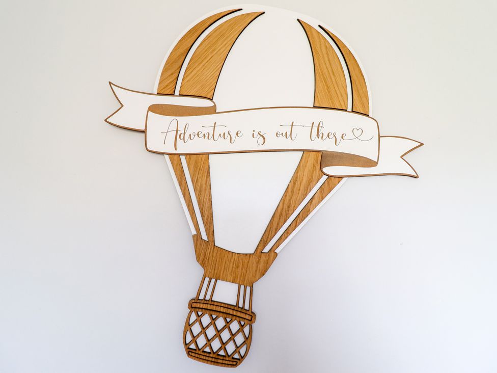 A decorative hot air balloon wall art with a banner saying Adventure is out there at Chy Bean in Abergele