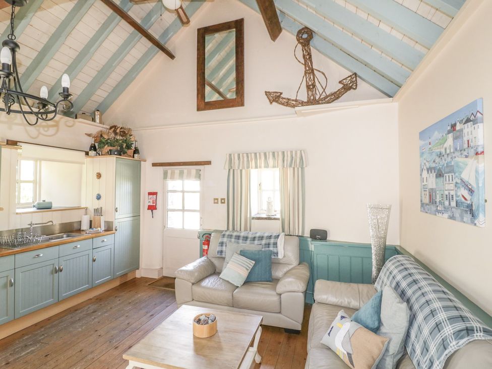 A living room with a sofa and coffee table at Dovecote in Gorran Haven