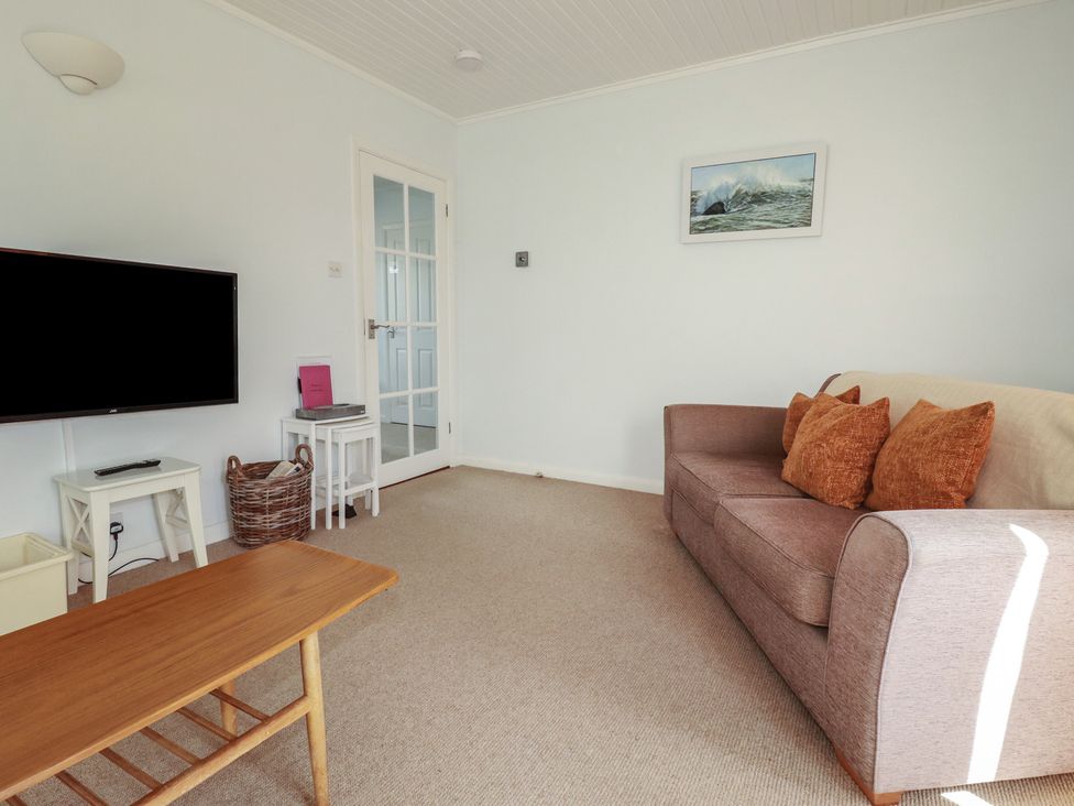 A living room with a sofa and television at Treverrion in Gorran Haven