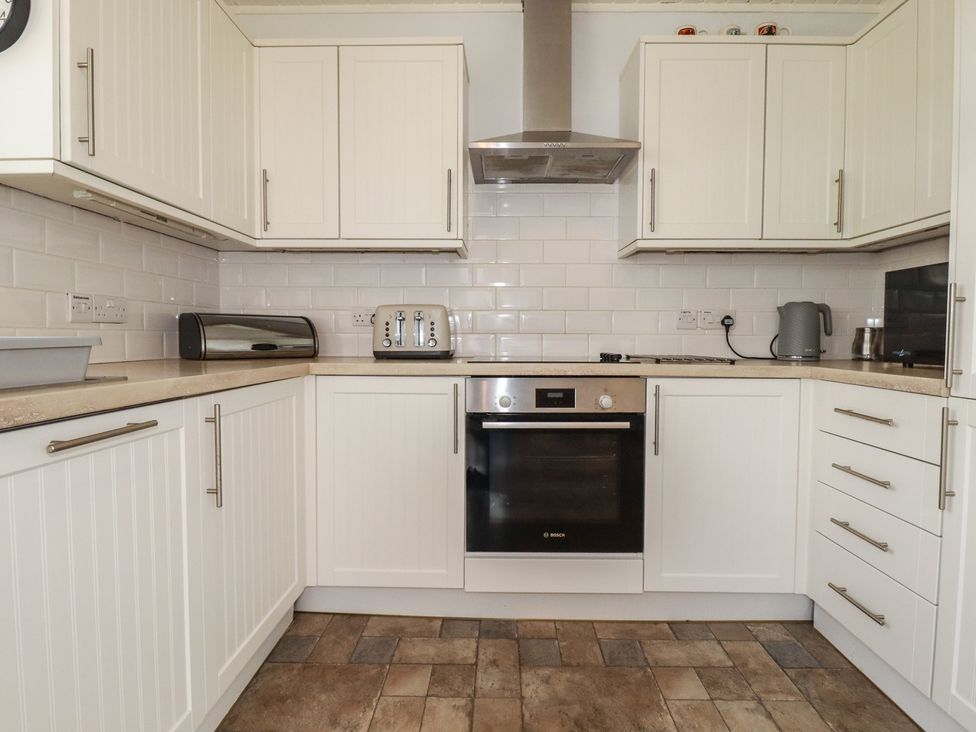 A kitchen with cabinets countertop and appliances at Treverrion in Gorran Haven