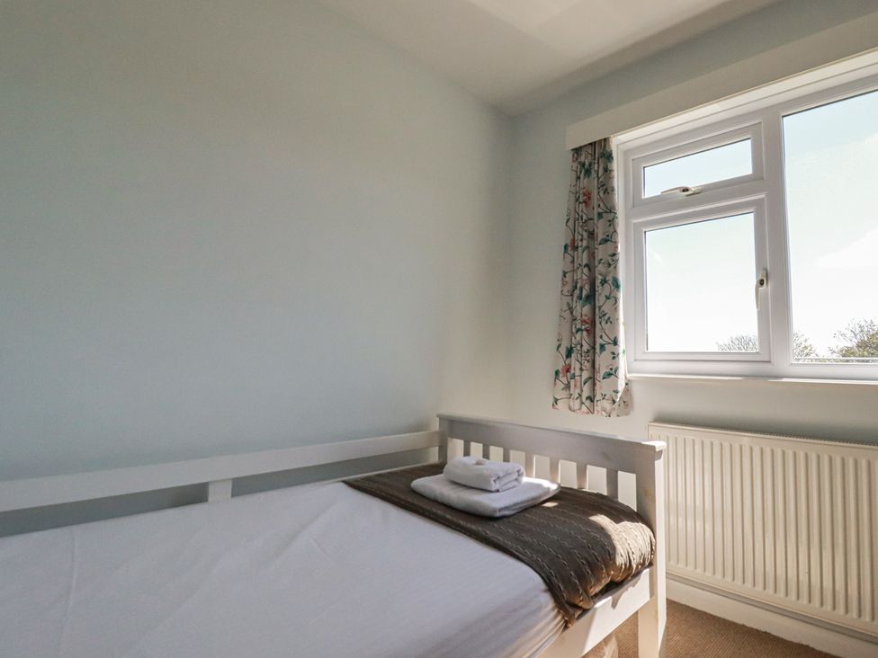A bedroom with a bed and window at Treverrion in Gorran Haven