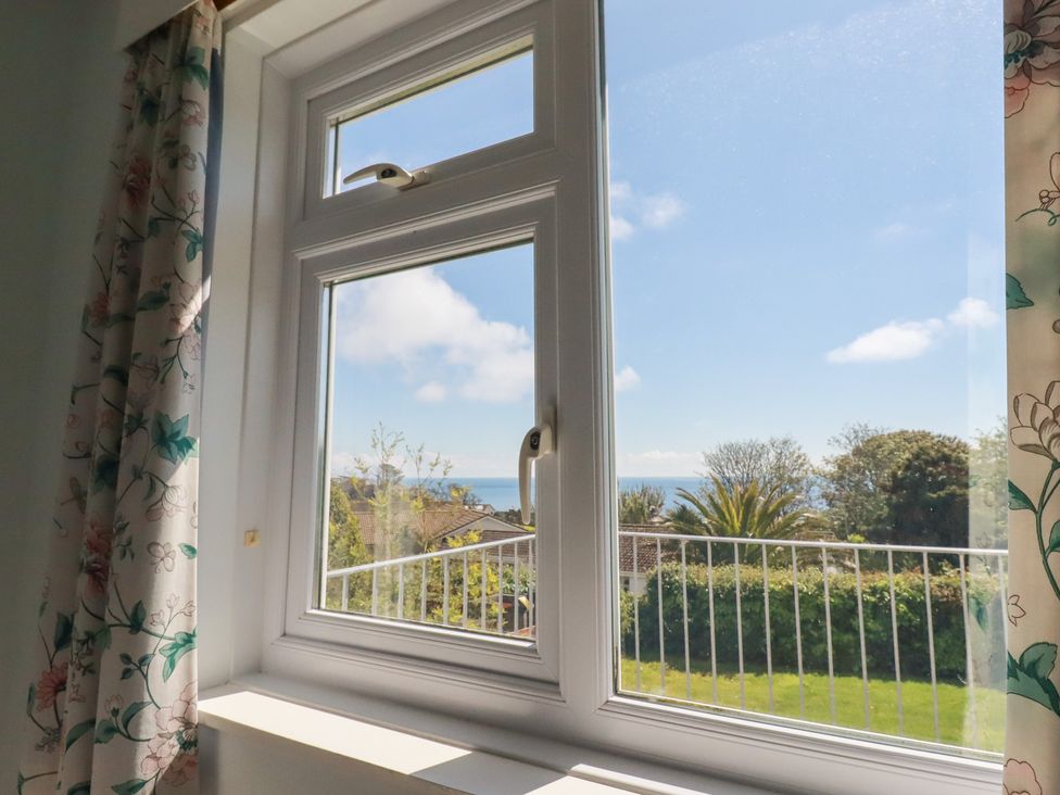 A window with a view of the sea and garden at Treverrion in Gorran Haven