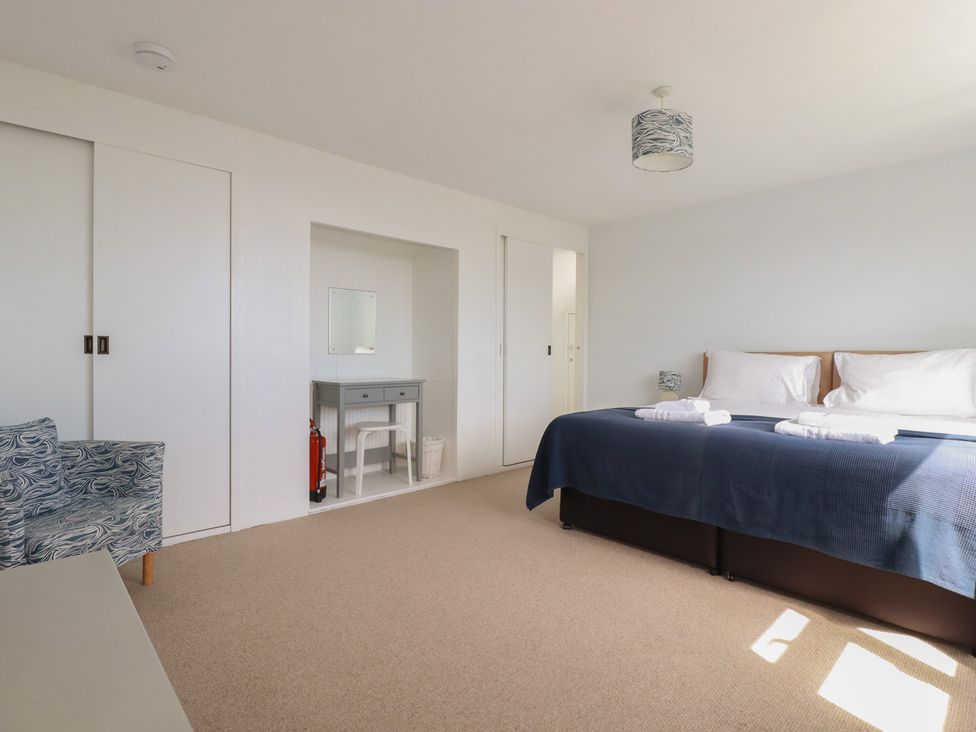 A bedroom with a bed and a desk at Treverrion in Gorran Haven