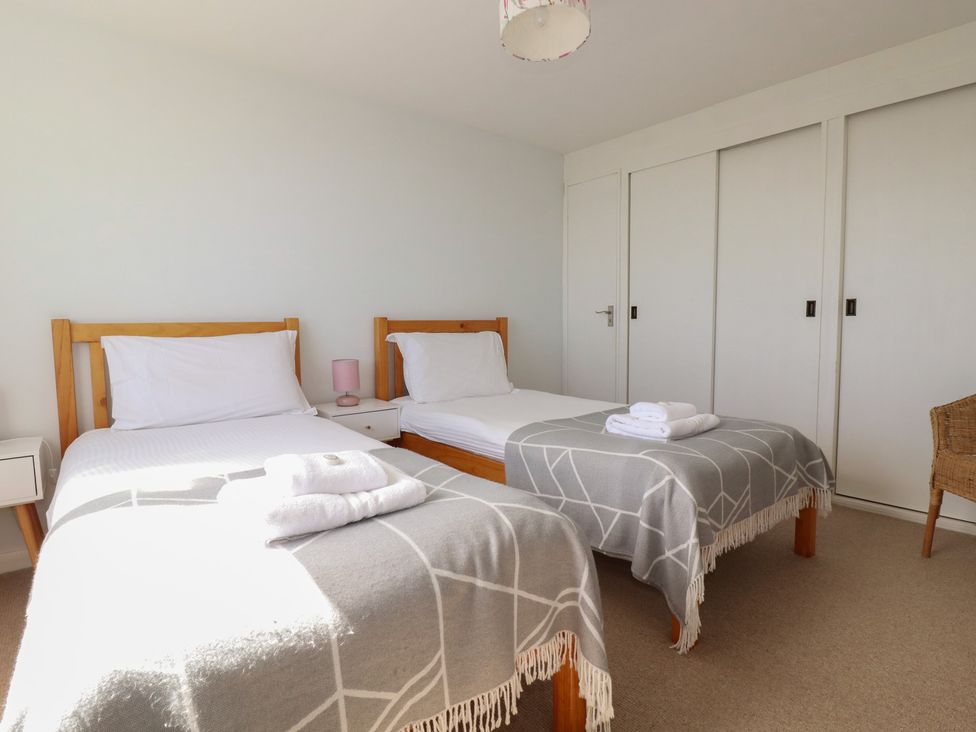 A bedroom with two beds and a nightstand at Treverrion in Gorran Haven